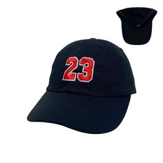 a hat with the number 23 embroidered on it and a black cap in front of it