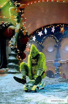 a man dressed as a monster riding a skateboard in front of christmas trees and decorations