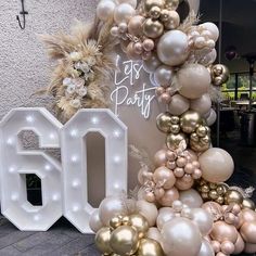 a large number 50 is surrounded by balloons and other decorations in gold, white and silver