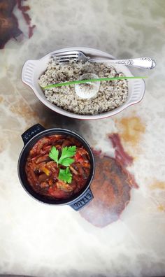 two bowls filled with food sitting on top of a table