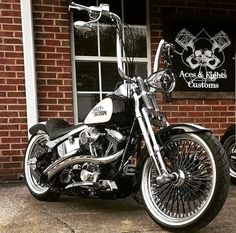 a black and white motorcycle parked in front of a brick building next to a window