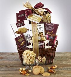 a gift basket filled with cookies, crackers and chocolates on top of a wooden table