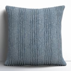 a blue striped pillow sitting on top of a white wall