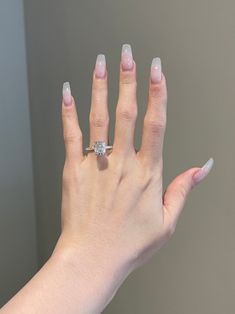 a woman's hand with a ring on top of her finger and a diamond in the middle