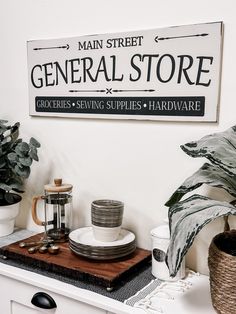 there is a sign that says general store on the wall next to some dishes and cups