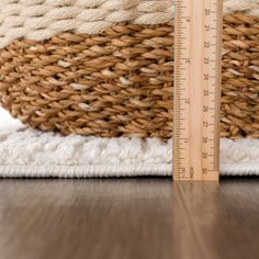 a measuring tape is on the floor next to a basket with woven material in it