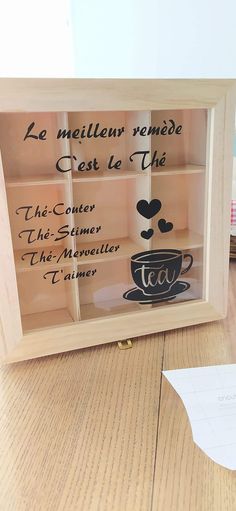 a wooden box with some writing on it and a coffee cup in the bottom shelf