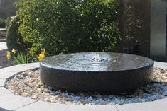 a water fountain surrounded by rocks and gravel