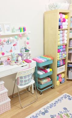 a room filled with lots of crafting supplies on shelves next to a desk and chair