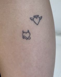 a woman's thigh with two small tattoos on it