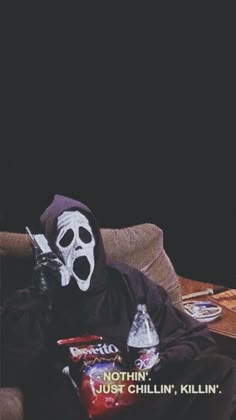 a person wearing a mask sitting on a couch with some snacks in front of them