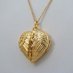 Angel Wings Heart Locket - 14K Gold Plated Sterling Silver - Memorial Love *NEW* This Angel Wing Locket is made of 14k Gold Plated Sterling Silver and is a FashionJunkie4Life original design!  Dimensions: 20mm x 20mm (3/4" x 3/4") Gold plating for this locket is 40 micro inches (1 micron) thick. It is a gem quality plate. Many people have had negative experiences with gold plated jewelry that has a thin wash of gold as little as 1 micro inch thick. Our gold plate is 40 TIMES as thick, at 40 micro inches (1 micron). We find this thickness to be extremely durable. Comes with an 18" 14k gold plated sterling silver cable chain.  Arrives in a gift box. Shipping Details: All orders are shipped within 1 business day (excluding US Holidays) All orders are shipped from Texas, USA International Buye Angel Wings Locket Necklace, Jewellery Tray, Angel Wings Heart, Diamond Initial Necklace, Necklace Heart, Heart Locket, Fantasy Jewelry, Girly Jewelry, Dream Jewelry