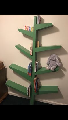 there is a book shelf with books on it and a stuffed animal in the corner