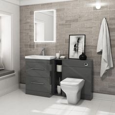 a white toilet sitting next to a sink in a bathroom under a mirror above a window