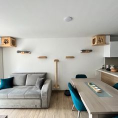 a living room filled with furniture next to a kitchen and dining room table covered in blue chairs