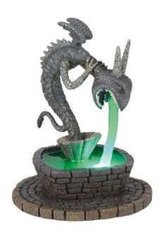 a statue of a dragon drinking out of a fountain with water coming out of it