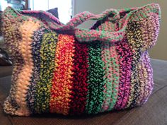 a multicolored purse sitting on top of a couch