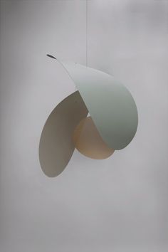 a white light hanging from a ceiling in the middle of a cloudy sky with an object suspended above it