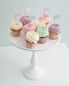 baby shower cupcakes with pink, blue and green frosting on a cake plate