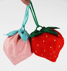 two strawberry shaped bags hanging from strings