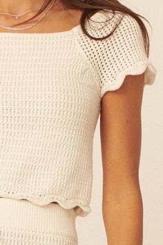 Crochet knit top. Boat neckline. Short raglan sleeves. Scalloped edge detail at sleeves and hem. Sleeveless lining. Cropped length. Fitted silhouette. 100% Cotton. Imported. Designed in LA. Model wears size S. Spring Crochet Trim Knit Top With Crew Neck, Spring Knit Top With Crochet Trim Crew Neck, Spring Crochet Trim Crew Neck Knit Top, Cropped Crochet Top With Textured Knit, Cropped Textured Knit Top For Summer, Spring Crew Neck Tops With Scalloped Edges, Spring Knit Tops With Scalloped Edges, Knit Top With Crochet Trim Crew Neck, Crew Neck Knit Top With Crochet Trim