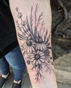 a black and white flower tattoo on the arm