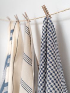 three blue and white checkered towels hanging on a clothes line