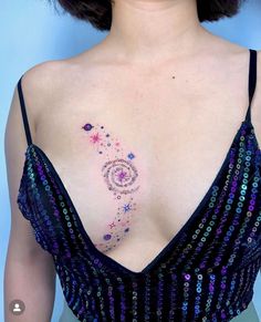 a woman's chest with an abstract tattoo design on her left shoulder and breast