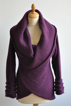 a mannequin wearing a purple shirt and scarf on top of a white table