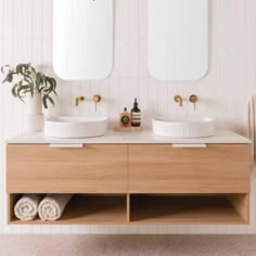 a bathroom with two sinks and mirrors on the wall