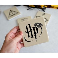 harry potter coasters are being held by someone's hand