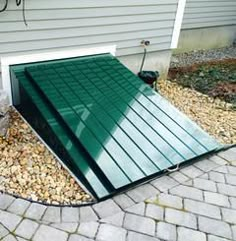 a green metal roof sitting on top of a brick walkway next to a garage door