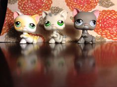 three little kitten figurines sitting on top of a table