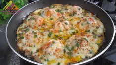 a skillet filled with cheese covered meat and veggies on top of a stove