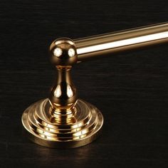 a golden metal object sitting on top of a wooden table next to a black background