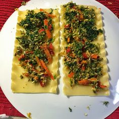 two pieces of ravioli on a plate with cheese and toppings, ready to be eaten