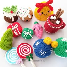 small crocheted toys are arranged on a white surface, including candy and lollipops