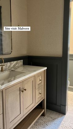 a bathroom with a sink and mirror next to a wallpapered area in the room