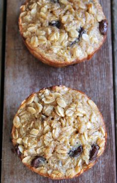 two oatmeal muffins sitting on top of a wooden table next to each other