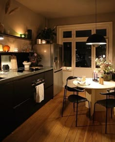 a kitchen with a table and chairs in it, next to a window that looks out onto the city