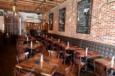 tables and chairs in a restaurant with brick walls