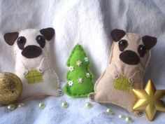 two small stuffed dogs sitting next to each other near a christmas tree and gold star