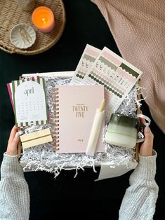 a person holding a box filled with lots of things to put in it's hands