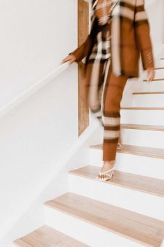 a blurry photo of a woman walking down the stairs with her hand in her pockets