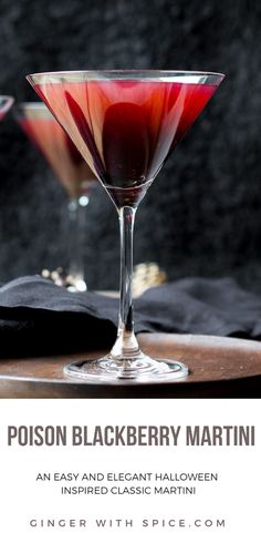 two glasses filled with red liquid sitting on top of a wooden table next to each other