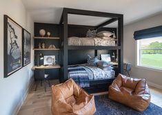 a bedroom with bunk beds and leather chairs in the corner, along with two framed pictures on the wall