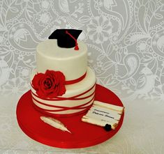 a red and white cake with a graduation cap on top