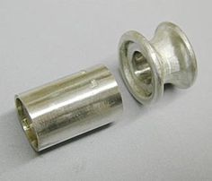 two metal parts on a white surface, one has a nut and the other is an end