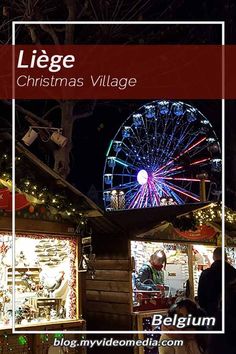 the christmas village is lit up at night with lights and ferris wheel in the background