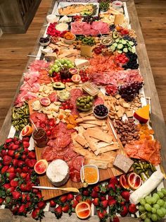 a long table filled with lots of different types of meats and cheeses on it